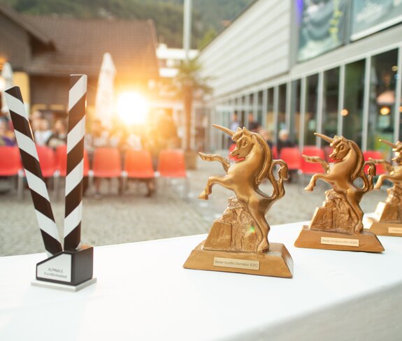 ALPINALE Goldenes Einhorn | © Anna Salcher Die Trophäen, das Goldene Einhorn, stehen auf einem Tisch vor den Zuschauerreihen beim Alpinale Kurzfilmfestival bereit. | © Anna Salcher